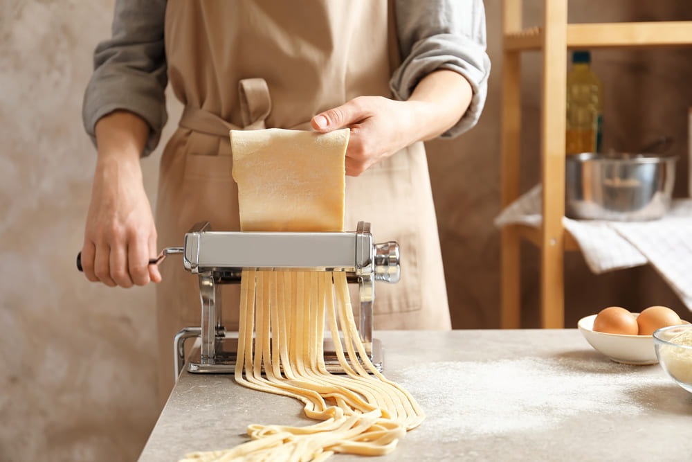 mujer utilizando maquina para hacer pasta